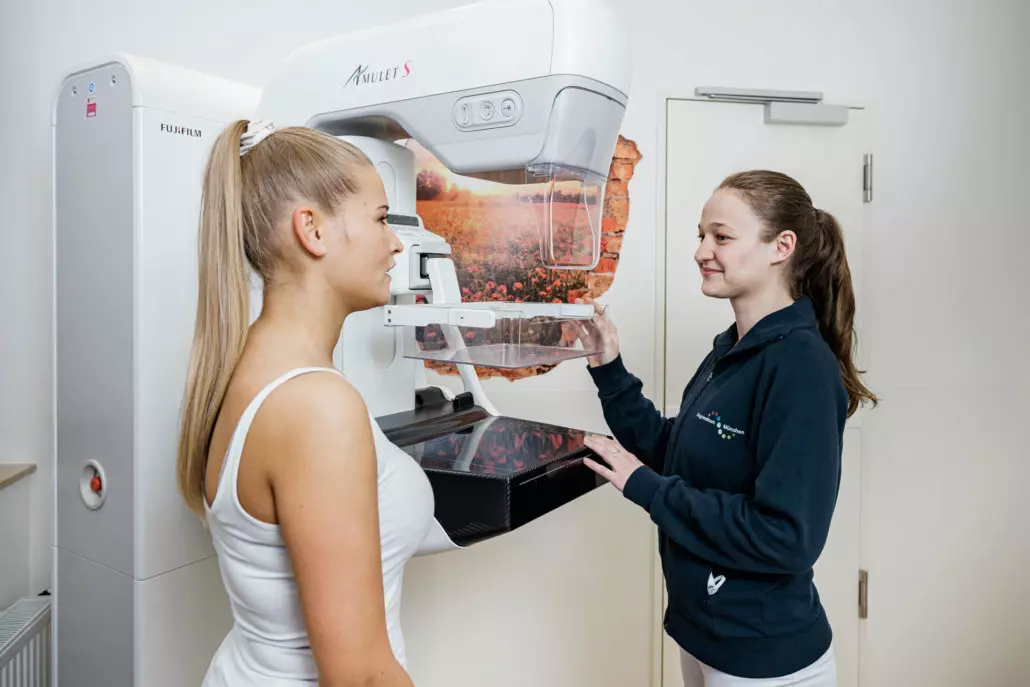 Eine Ärztin erklärt einer Patientin den Ablauf einer Mammographie